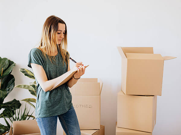 A woman makes a checklist for putting items into storage