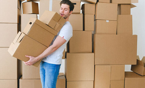 A man holding lost of storage boxes